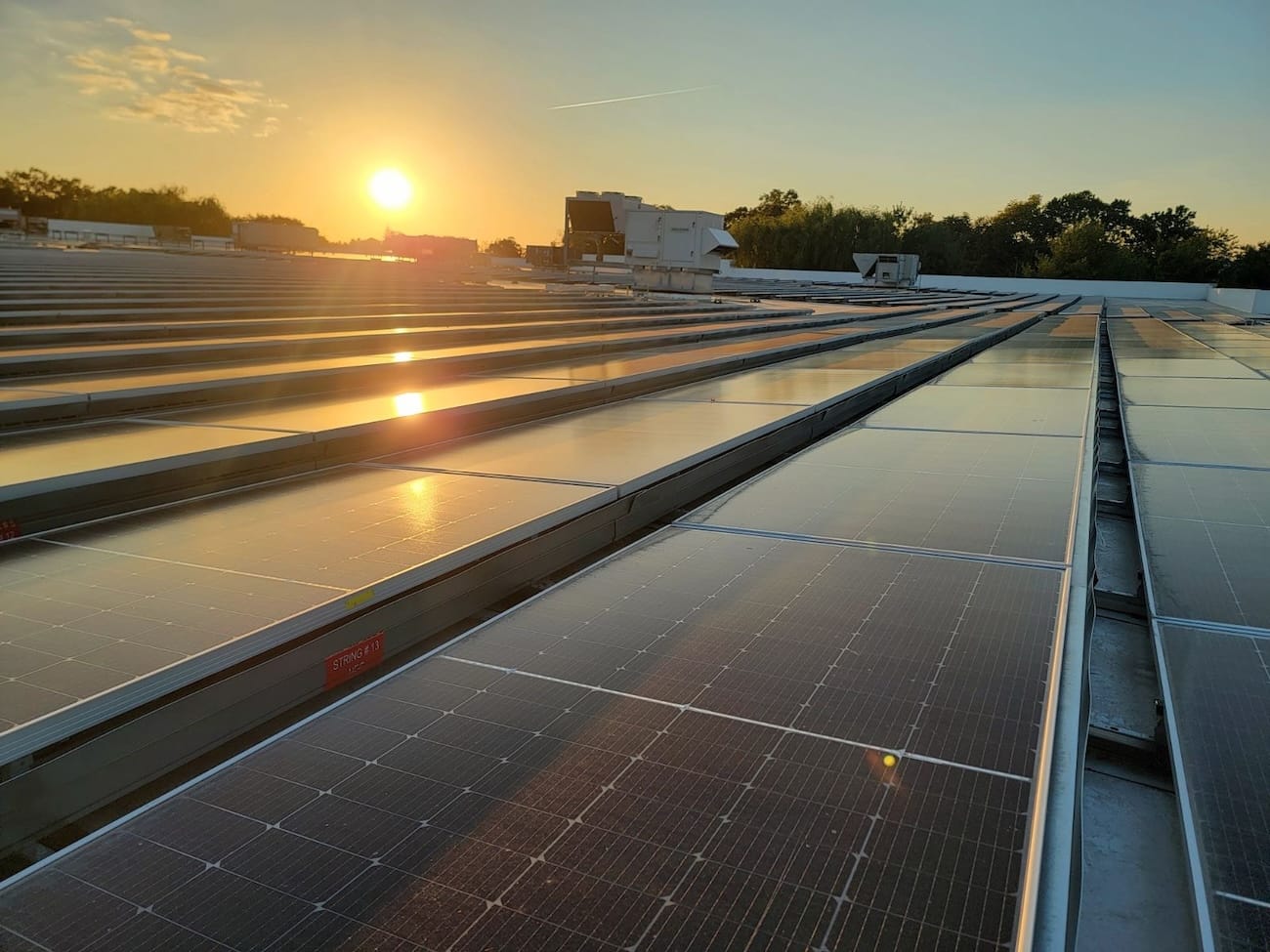Solar panels on a rooftop at sunrise, harnessing solar energy for a large facility